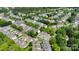 Aerial view of neighborhood with mature trees surrounding homes, green spaces, and roads at 8009 Whitehawk Hill Rd, Waxhaw, NC 28173