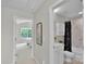 Hallway view to bathroom with vanity and shower and bedroom with a ceiling fan and natural light at 8009 Whitehawk Hill Rd, Waxhaw, NC 28173