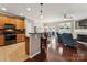 Open-concept kitchen with island, stainless appliances, and hardwood floors throughout the living area at 8009 Whitehawk Hill Rd, Waxhaw, NC 28173