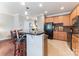 Kitchen with wood cabinets, bar seating, tile floors, and a view of the breakfast nook with adjacent living area at 8009 Whitehawk Hill Rd, Waxhaw, NC 28173