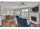 Bright living space with a fireplace, ceiling fan, adjacent dining area, and hardwood floors at 8009 Whitehawk Hill Rd, Waxhaw, NC 28173