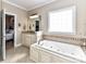 A bright bathroom boasts a soaking tub with tiled surround, vanity, and large window at 816 Springs Rd, Dallas, NC 28034