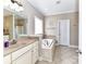 Bathroom featuring a soaking tub, double vanity with granite countertop and tiled flooring at 816 Springs Rd, Dallas, NC 28034