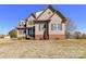 Charming two-story home featuring light brown siding, brick base, and shuttered windows at 816 Springs Rd, Dallas, NC 28034