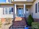 Elegant front entrance with a blue door, brick steps, and decorative landscaping at 816 Springs Rd, Dallas, NC 28034