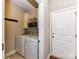 This laundry room features a front-load washer, a front-load dryer, overhead storage, a rack of hooks, and a door at 816 Springs Rd, Dallas, NC 28034