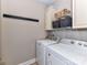 This laundry room features a front-load washer, a front-load dryer, overhead storage, and a rack of hooks at 816 Springs Rd, Dallas, NC 28034