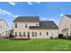 Home back exterior has a wooden deck, a grassy yard and beige siding at 8806 Cool Meadow Dr, Huntersville, NC 28078