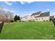 Large lush backyard showcasing plenty of open grass space surrounded by dark fences at 8806 Cool Meadow Dr, Huntersville, NC 28078