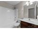 Neutral bathroom features a shower-tub combo, vanity with sink, and neutral-toned walls at 8806 Cool Meadow Dr, Huntersville, NC 28078