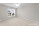 Comfortable bedroom featuring neutral carpet and a window bringing in natural light at 8806 Cool Meadow Dr, Huntersville, NC 28078