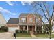 Charming two-story brick home featuring a covered front porch and well-maintained landscaping at 8806 Cool Meadow Dr, Huntersville, NC 28078