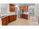 Modern kitchen with stainless steel refrigerator, granite countertops, and wood cabinetry at 8806 Cool Meadow Dr, Huntersville, NC 28078