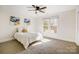 Cozy bedroom with carpet, large windows, and a ceiling fan at 9239 Silver Pine Dr, Charlotte, NC 28277