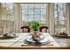 Bright dining area with large windows and a round table beautifully set for a meal at 9239 Silver Pine Dr, Charlotte, NC 28277