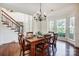 Well-lit dining room with bay windows, wood floors, and classic chandelier at 9239 Silver Pine Dr, Charlotte, NC 28277
