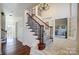 Inviting foyer with staircase, hardwood floors, and decorative railing at 9239 Silver Pine Dr, Charlotte, NC 28277