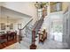 Elegant foyer with staircase, chandelier, and dining room for a welcoming entry at 9239 Silver Pine Dr, Charlotte, NC 28277