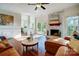 Sunlit living room features a brick fireplace, hardwood floors, and sliding glass doors to the outdoors at 9239 Silver Pine Dr, Charlotte, NC 28277