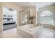 Bright and airy main bathroom with a large tub, shower, and a view to the bedroom at 9239 Silver Pine Dr, Charlotte, NC 28277