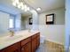 Bright bathroom featuring double sink vanity, decorative mirror, and wainscoting at 1000 Sweetgum St, Gastonia, NC 28054