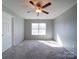 Neutral bedroom with carpet, a ceiling fan, and a large window for natural light at 1000 Sweetgum St, Gastonia, NC 28054