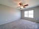 Neutral bedroom with carpet, a ceiling fan, and a large window for natural light at 1000 Sweetgum St, Gastonia, NC 28054