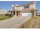 Suburban two-story home exhibiting stone accents, an attached garage, and a nicely landscaped front yard at 1000 Sweetgum St, Gastonia, NC 28054