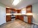 Well-lit kitchen boasts stainless steel appliances, rich wood cabinetry, granite countertops, and stylish backsplash at 1000 Sweetgum St, Gastonia, NC 28054