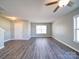 Contemporary living space showcasing laminate flooring, a ceiling fan, and abundant natural light from a large window at 1000 Sweetgum St, Gastonia, NC 28054