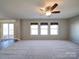 Expansive living room featuring a ceiling fan, natural light, and seamless access to the backyard at 1000 Sweetgum St, Gastonia, NC 28054