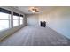 Open living room with fireplace, ceiling fan, large windows and neutral carpeting at 1000 Sweetgum St, Gastonia, NC 28054