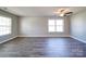 Spacious living area featuring laminate flooring, a ceiling fan, and large windows for plenty of natural light at 1000 Sweetgum St, Gastonia, NC 28054