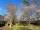 Landscaped backyard with flowering trees, a wooden deck, and room for outdoor activities at 104 Johnsbury Dr, Stanley, NC 28164