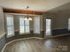 Dining area featuring wood-look floors, a stylish light fixture, and shuttered windows at 104 Johnsbury Dr, Stanley, NC 28164