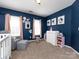 Bedroom with a blue accent wall, two windows, grey chair and carpet flooring at 12729 Mcginnis Ln, Huntersville, NC 28078