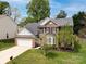 Beautiful two-story brick home featuring a manicured lawn, attached two-car garage, and lush landscaping at 12729 Mcginnis Ln, Huntersville, NC 28078