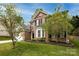 Inviting brick home featuring black shutters, flowering trees, and well-maintained landscaping at 12729 Mcginnis Ln, Huntersville, NC 28078