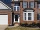 Charming brick home with a well-manicured lawn, black shutters, and front door at 12729 Mcginnis Ln, Huntersville, NC 28078