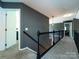 Upstairs hallway with carpet flooring, gray walls, and dark staircase railing at 12729 Mcginnis Ln, Huntersville, NC 28078
