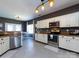 Well-lit kitchen featuring white cabinets, granite countertops, and stainless-steel appliances at 12729 Mcginnis Ln, Huntersville, NC 28078