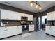 Well-lit kitchen with stainless steel appliances, white cabinets, and tile flooring at 12729 Mcginnis Ln, Huntersville, NC 28078