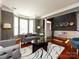 Bright living room with a gray sofa, accent chairs, hardwood floors, and large windows at 12729 Mcginnis Ln, Huntersville, NC 28078