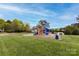 Community playground featuring a slide, climbing structure, and green space, ideal for outdoor fun at 12729 Mcginnis Ln, Huntersville, NC 28078