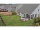 Spacious backyard featuring a built-in grill, patio, green lawn, and black metal fence at 141 Rhuidean Ct, Troutman, NC 28166