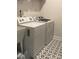 Well-lit laundry room with modern appliances and a unique star pattern on the tile floor at 141 Rhuidean Ct, Troutman, NC 28166