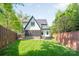 Spacious backyard featuring a screened porch, lush green lawn, and privacy fencing at 1711 Brook Rd, Charlotte, NC 28205