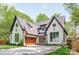 Charming home featuring a well-manicured lawn, striking dark trim and a stylish wooden garage door at 1711 Brook Rd, Charlotte, NC 28205