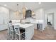 Kitchen with a large island, wine fridge, white cabinets, black accents, and pendant lights at 1711 Brook Rd, Charlotte, NC 28205
