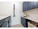 Modern laundry room features a sleek design with navy cabinets and a stylish subway tile backsplash at 1711 Brook Rd, Charlotte, NC 28205
